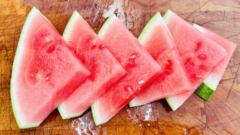 Triangles of watermelon lined-up on cutting board