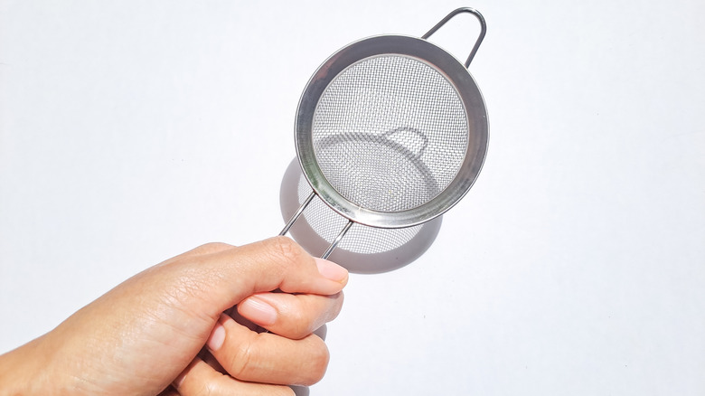 fine strainer held in a hand