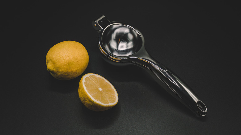 handheld juicer pictured alongside lemon