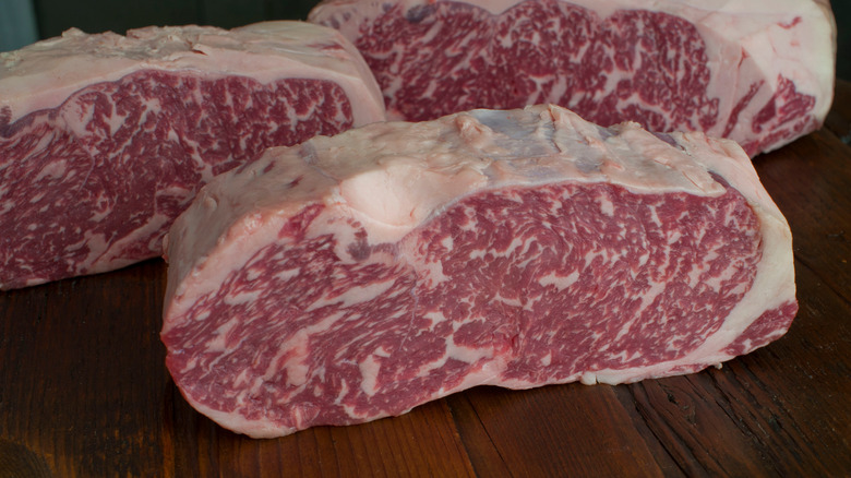 Waygu beef sits on a wooden surface