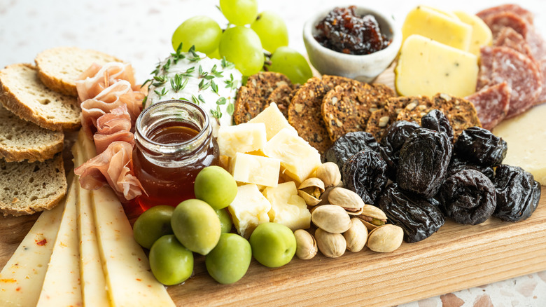Prunes on a charcuterie board with assorted meats and cheeses