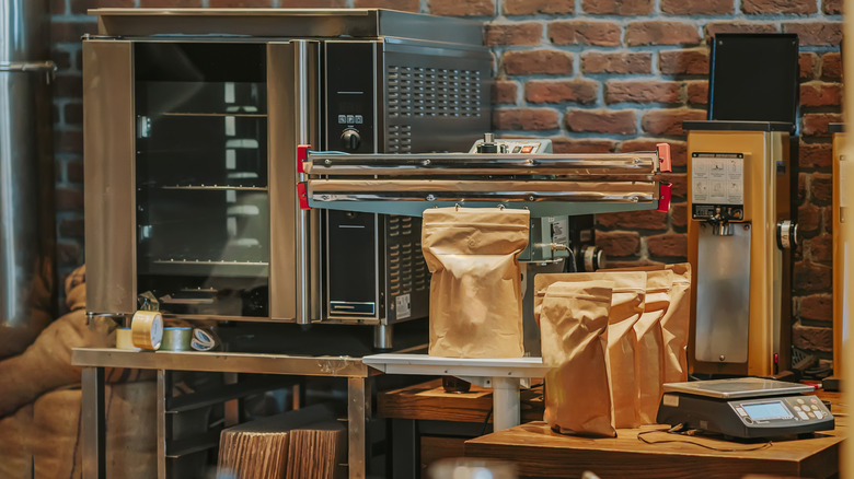 A variety of machines and bagged beans sit in a coffee shop