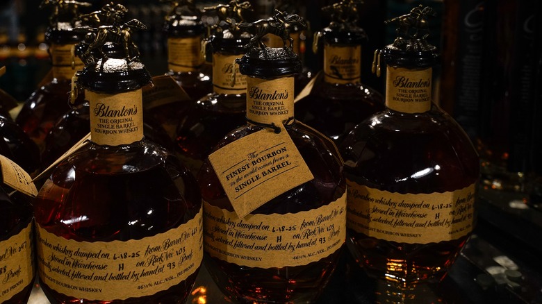 Blanton's original single barrel bourbon whiskey bottles are crowded together