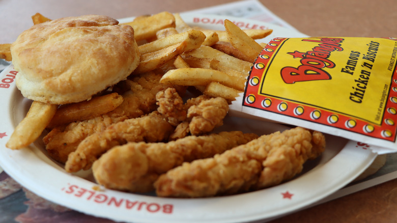 A plate containing Bojangles chicken tenders, french fries, and a biscuit