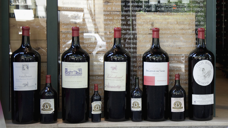 Large and small wine bottles on display outside of a French shop