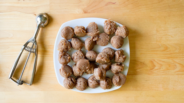 No-bake snickerdoodle cookie dough scoops on plate with small scoop