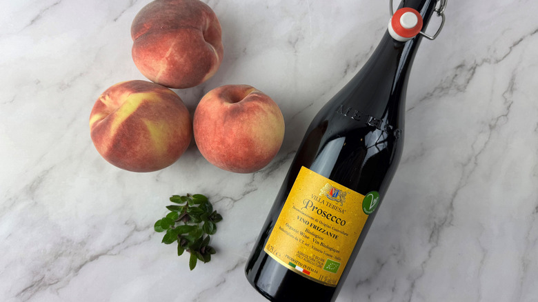 peaches, mint, and a bottle of sparkling wine