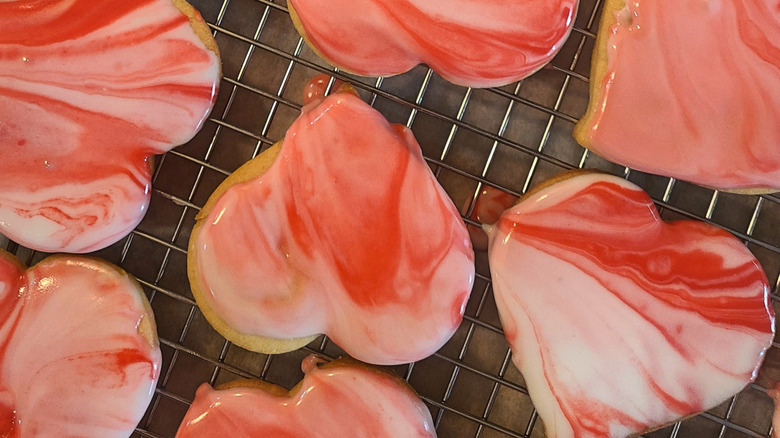 A full tray of tie-dye marbled pink and white heart cookies