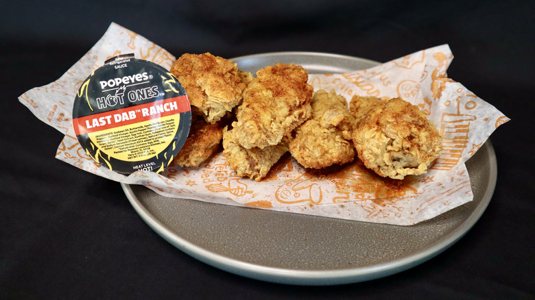 Hot Ones sauce next to chicken wings