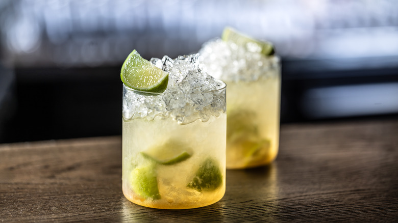 Two Caipirinhas on a wooden surface