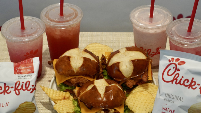 Close-up of Chick-fil-A Fall 2025 lineup on a tan table in front of a white Chick-fil-A step and repeat