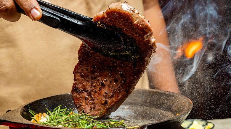 Chef cooking a picanha steak in a pan