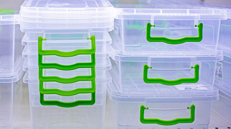 Clear plastic storager bins with green handles stacked
