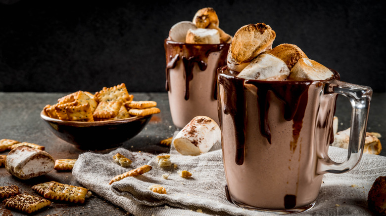 Two cups of chocolatey s'mores drinks with marshmallows on top.