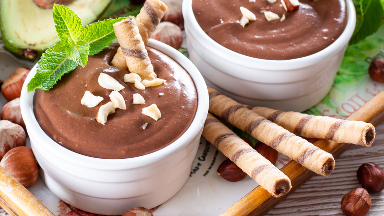 Two cups of chocolate dip with cookies