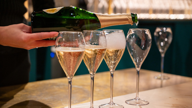 Person pouring glasses of sparkling wine