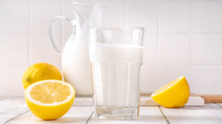 Buttermilk sits in a clear glass surrounded by lemons