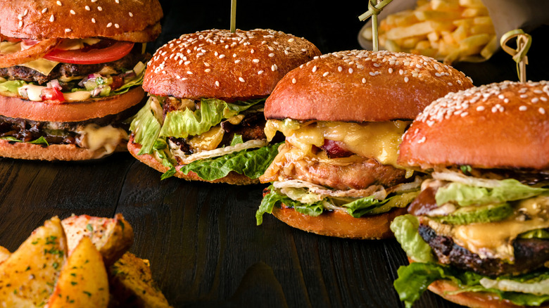 Assorted burgers with fries and potato wedges