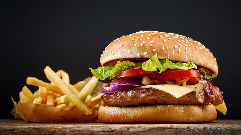 a hamburger and fries on a wooden table