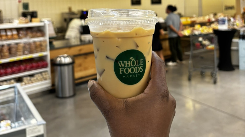 Hand holding a beverage from Whole Foods