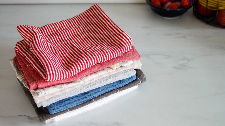 Kitchen towels folded and stacked on a counter.