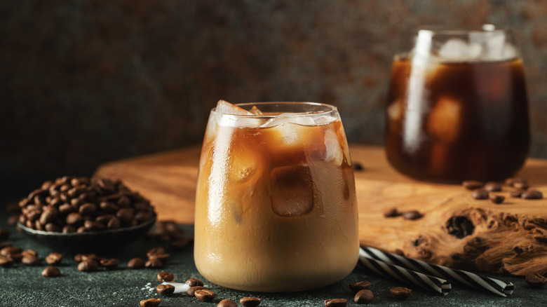 Glass of cold brew coffee with espresso beans in the background.