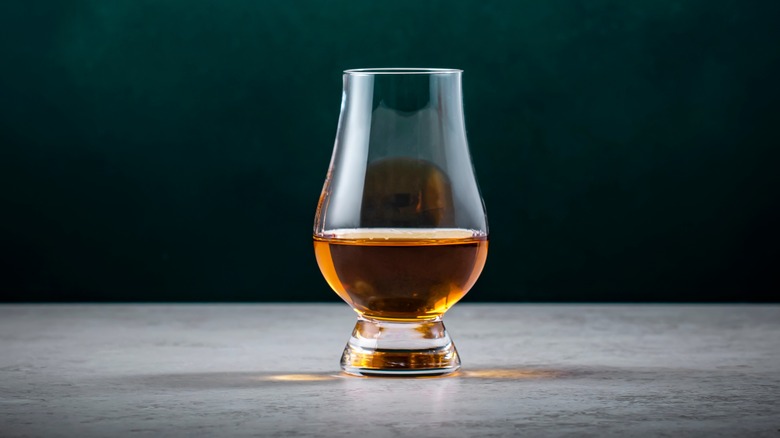 A Glencairn whisky glass contains a pour of the amber liquid