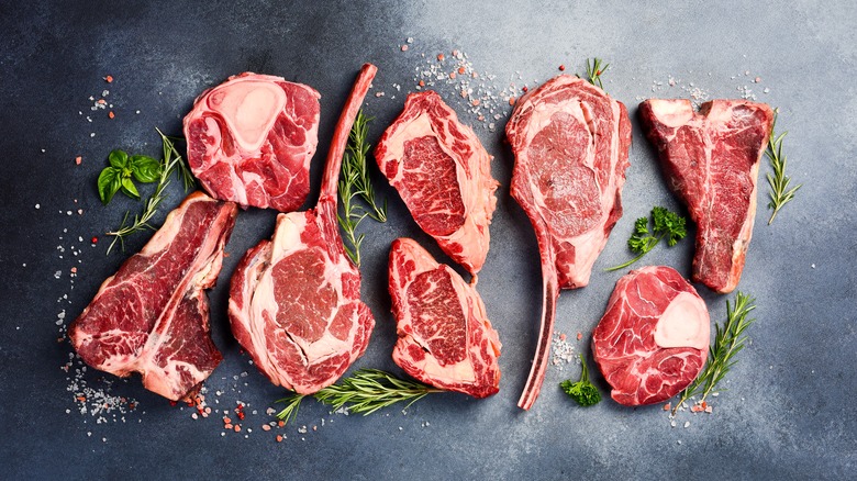 Variety of raw steaks on greay background
