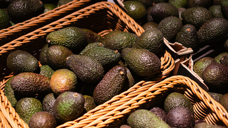 Baskets of Hass avocados at a market stall