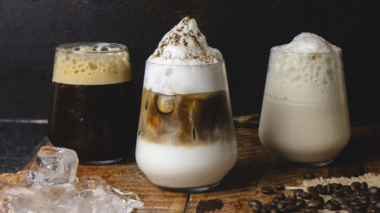 Different coffee varieties in glasses with creamy tops