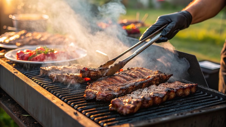 Cook grilling some red meat outdoors