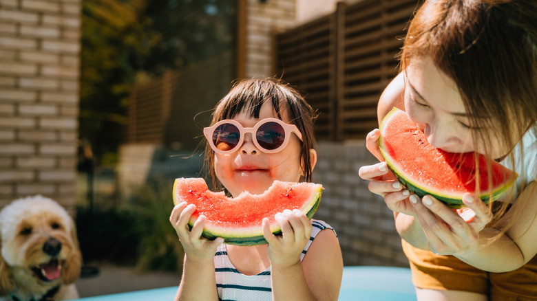A family enjoying juice slices of watermelon in the summer