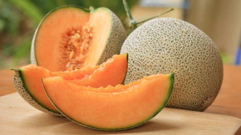 Fresh whole cantaloupe next to sliced cantaloupes