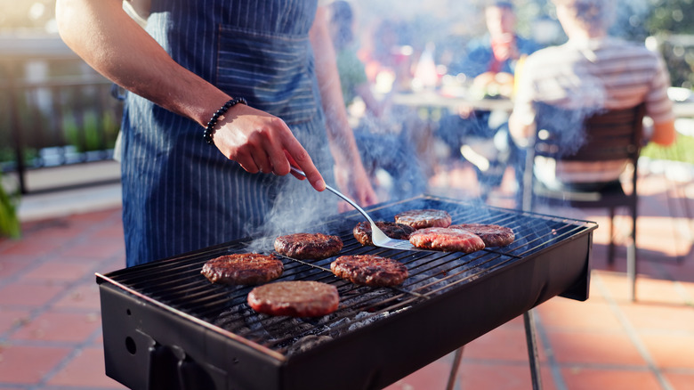 Person grilling burgers on the grill