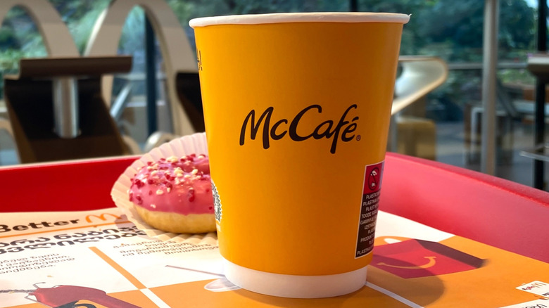 A McCafé cup next to a donut