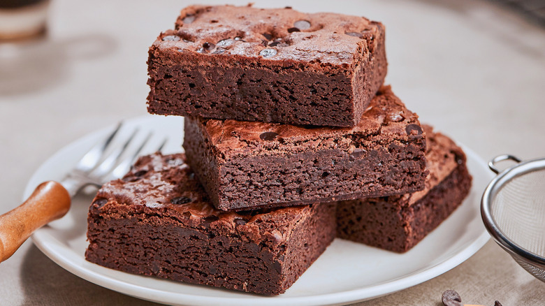 Three brownies stacked on plate