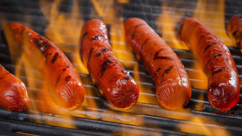 Hot dogs on a flaming grill
