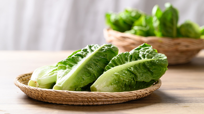 Romaine lettuce in a woven plate on a counter