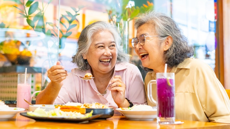 Two older women enjoying a meal at a restaurant together