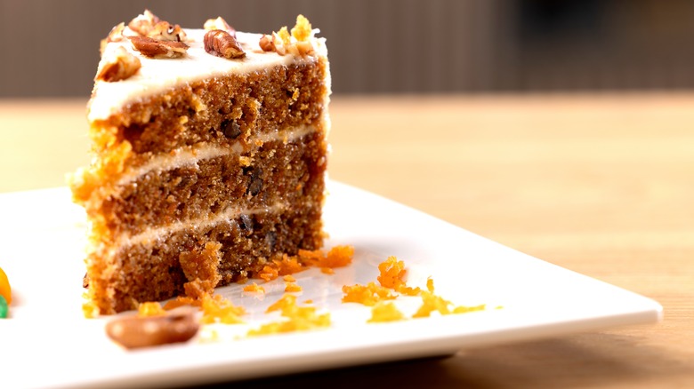 A slice of carrot cake on a white plate