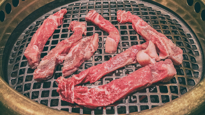 Raw steak rests on a Japanese grill.