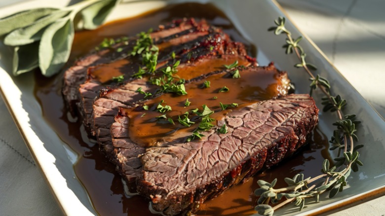 Sliced brisket covered with gravy and herbs