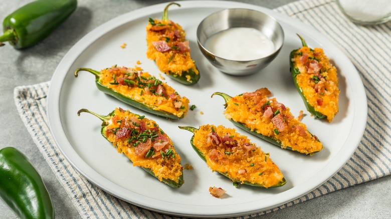 Jalapeño poppers on a plate with a dipping sauce