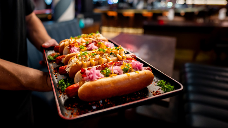 A tray of elaborately-dressed hot dogs