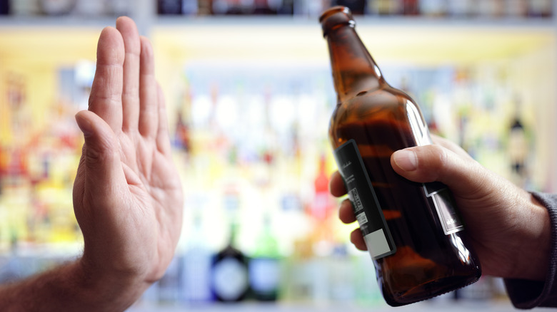 Hand rejecting a bottle of beer
