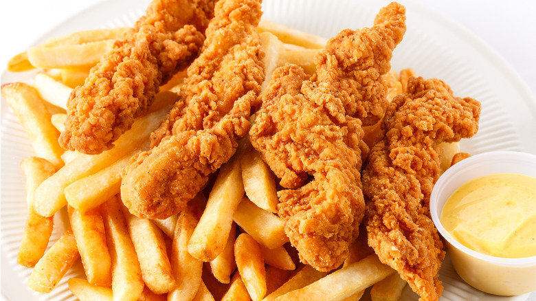 Crispy chicken tenders on a bed of fries