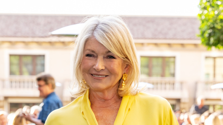 Martha Stewart in a yellow shirt smiling at an event.