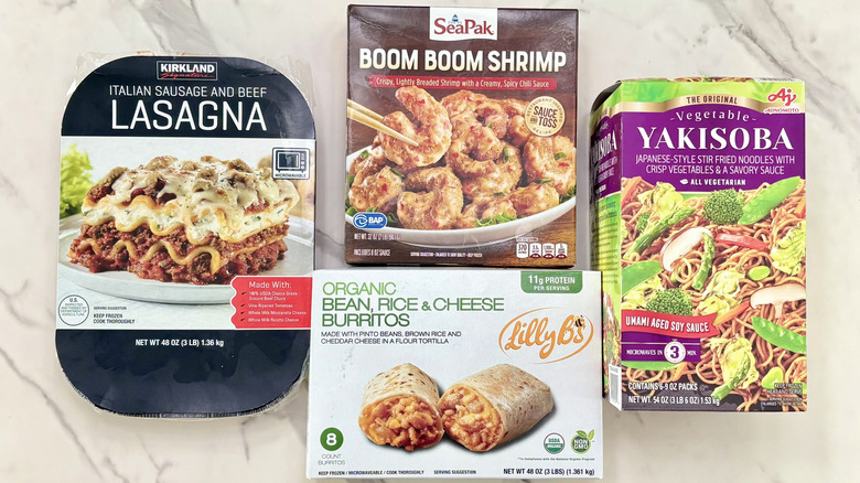 An assortment of Costco frozen dinners sits on a marble countertop