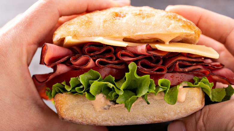 Closeup of hands holding a roast beef sandwich