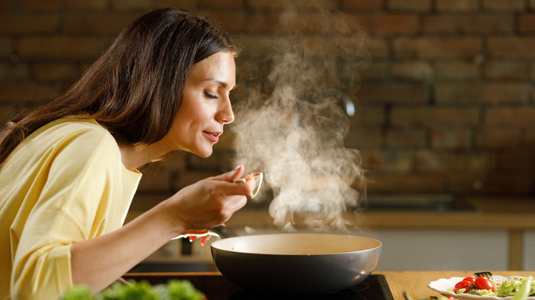 Woman cooking with pot on stove